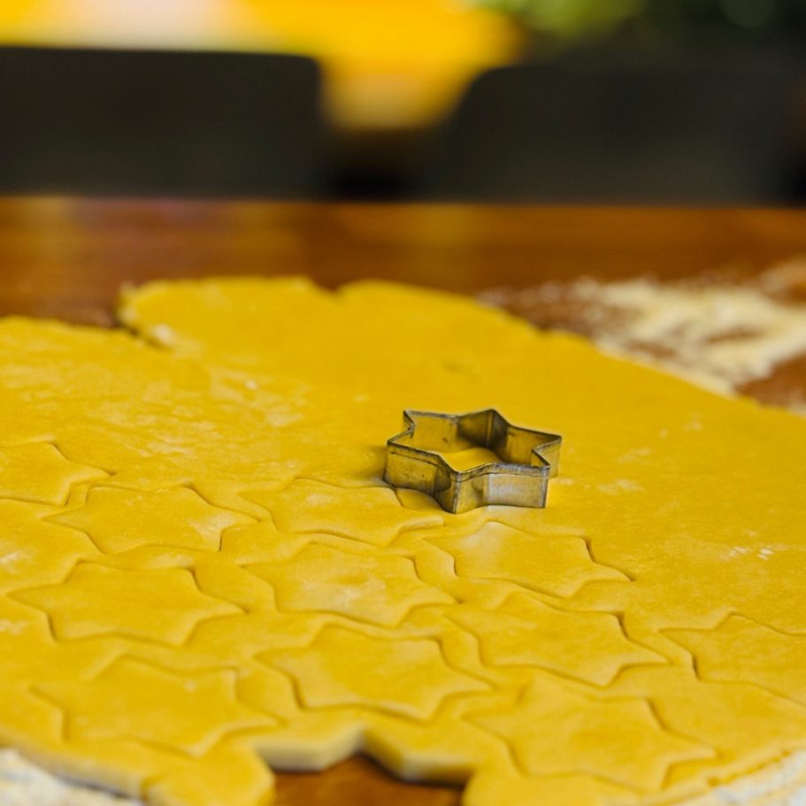 Ausgerollter Teig mit einem Ausstecher in Form eines Sterns.