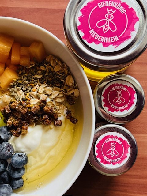 Schüssel mit Joghurt, Obst, Granola und Gläsern mit bunter, aufrechter Etikettierung.