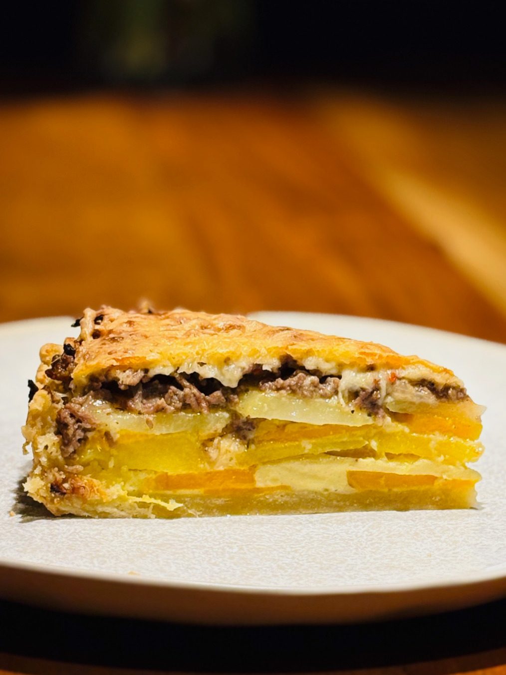 Stück Schichtkuchen mit gelben und braunen Lagen auf einem Teller.