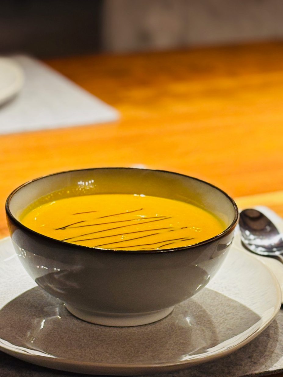 Schale mit cremiger Kürbissuppe, garnierte Oberfläche in einem Restaurant.