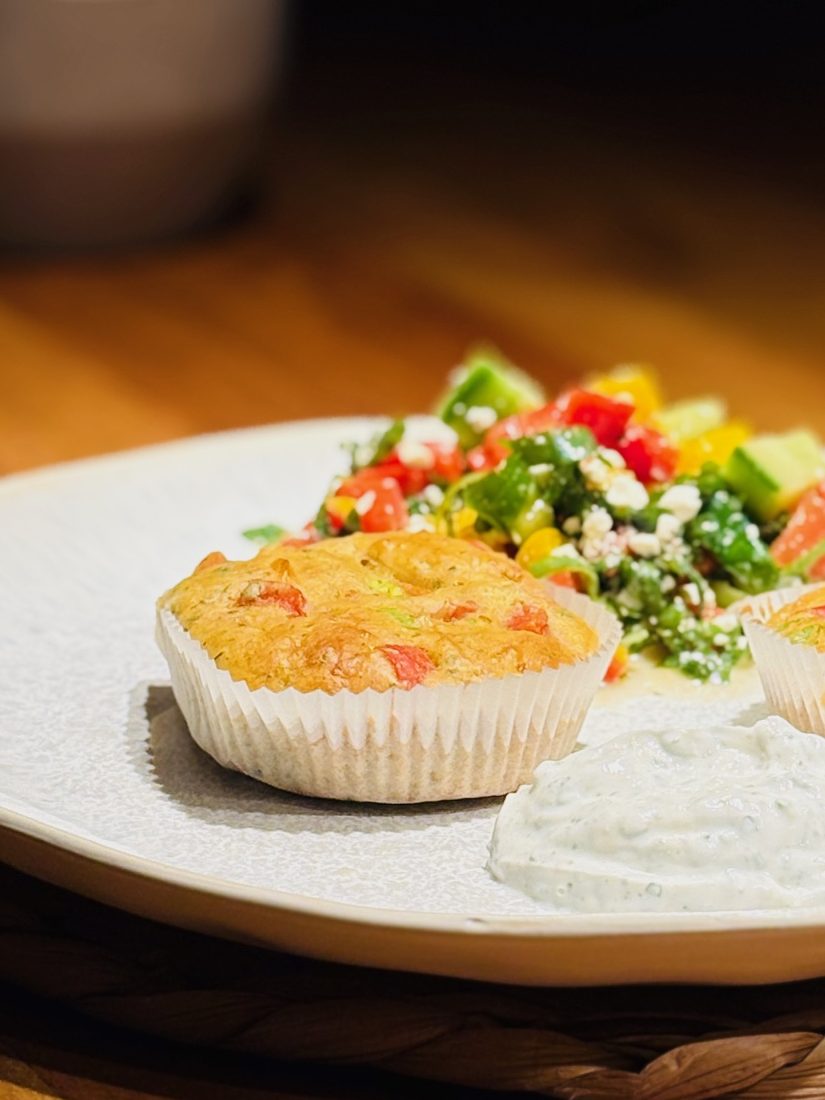 Ein Teller mit einem Muffin, Salat und Joghurt-Dip.