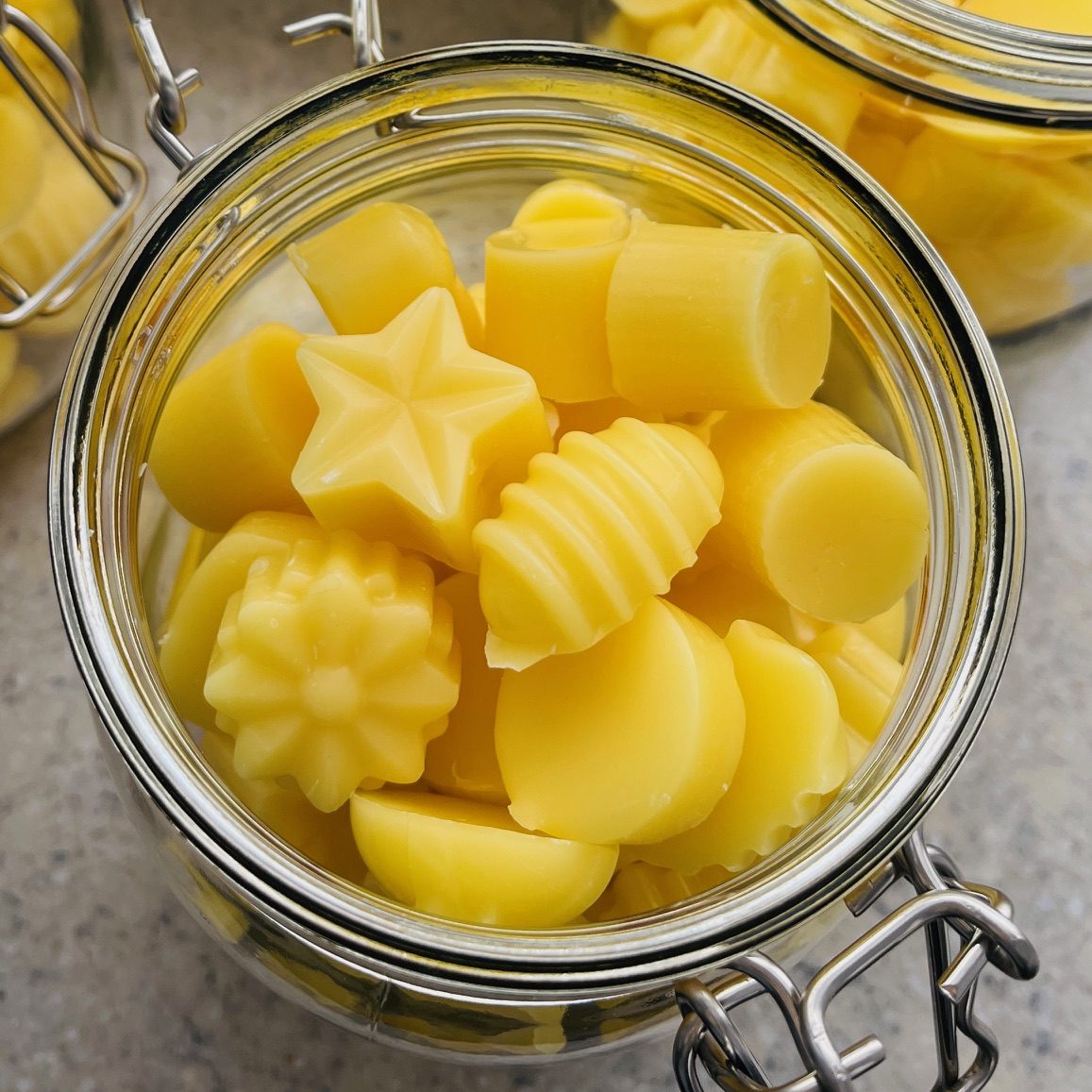 Gelbe, verschiedene Formen von Wachsmannschaften in einem Glasbehälter.