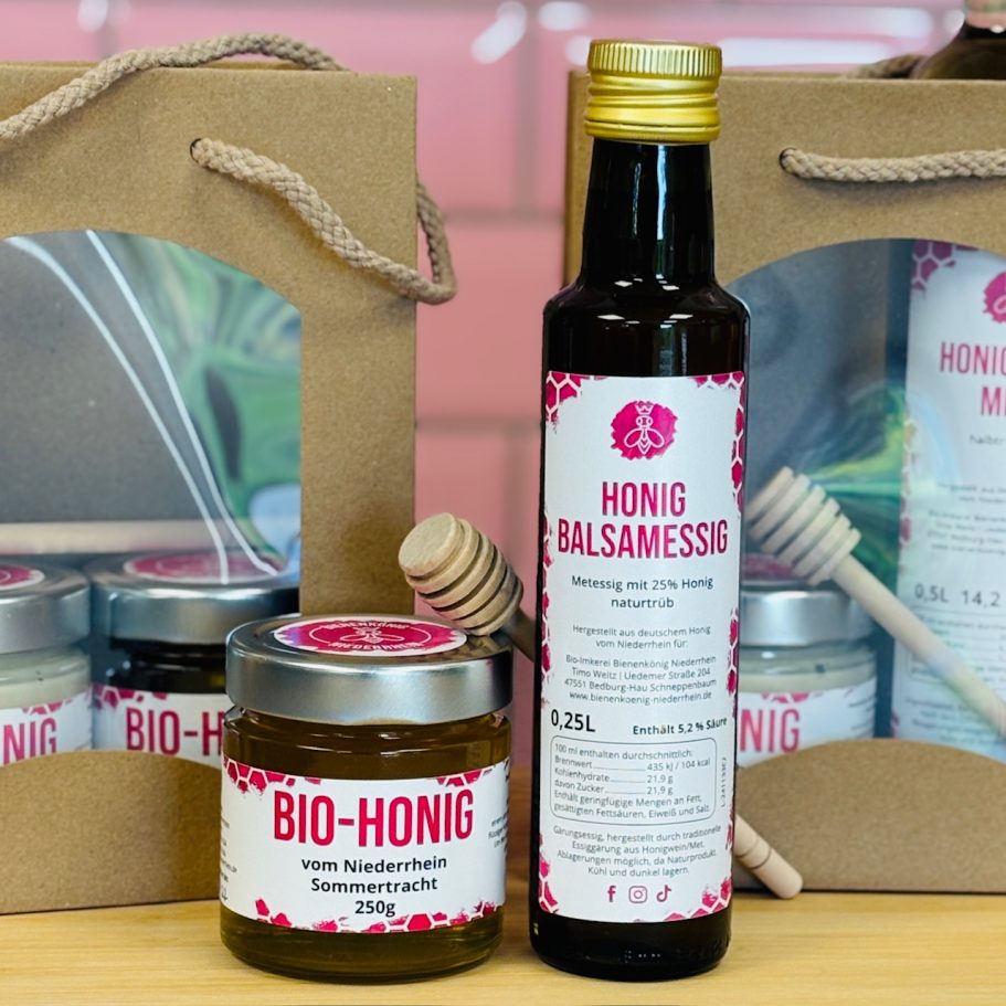 Glas mit Bio-Honig, Balsamessig und Holzlöffel in einer Geschenkverpackung.