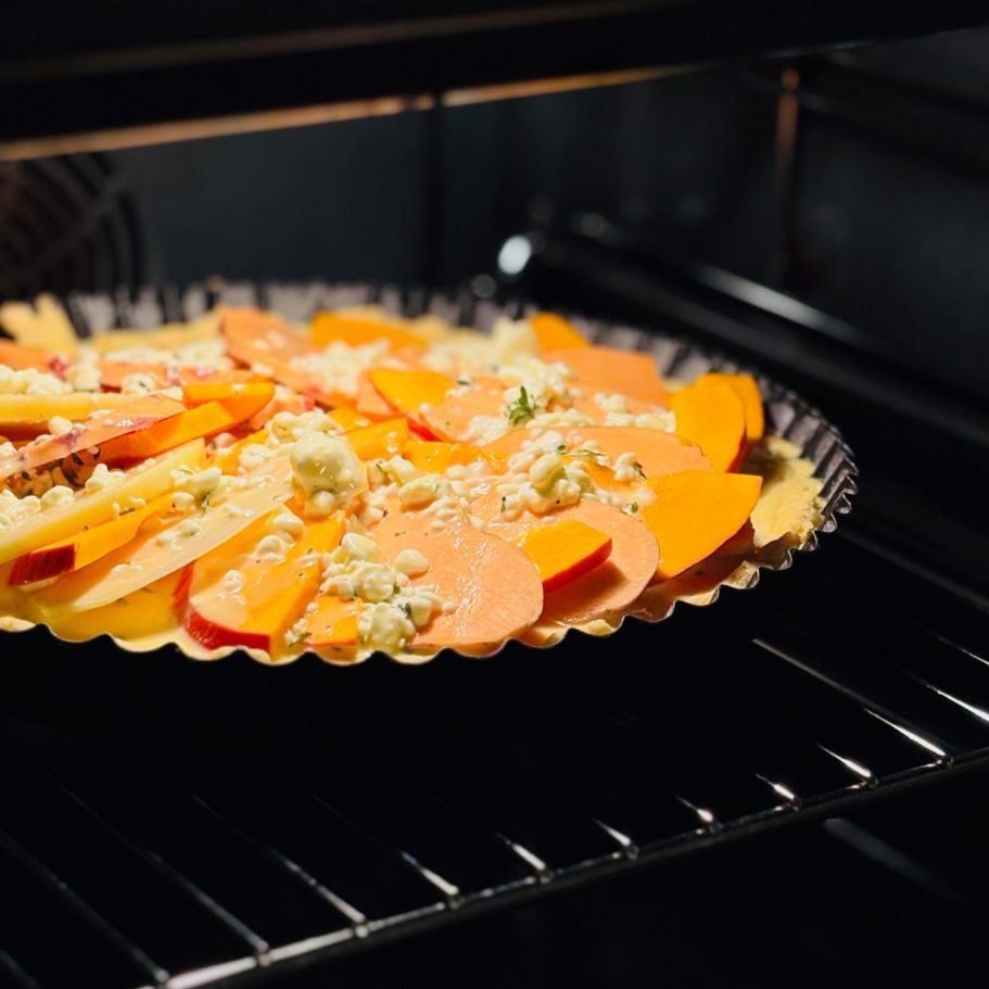 Zwei Hamburger mit frischem Gemüse auf einem Holzbrett serviert.