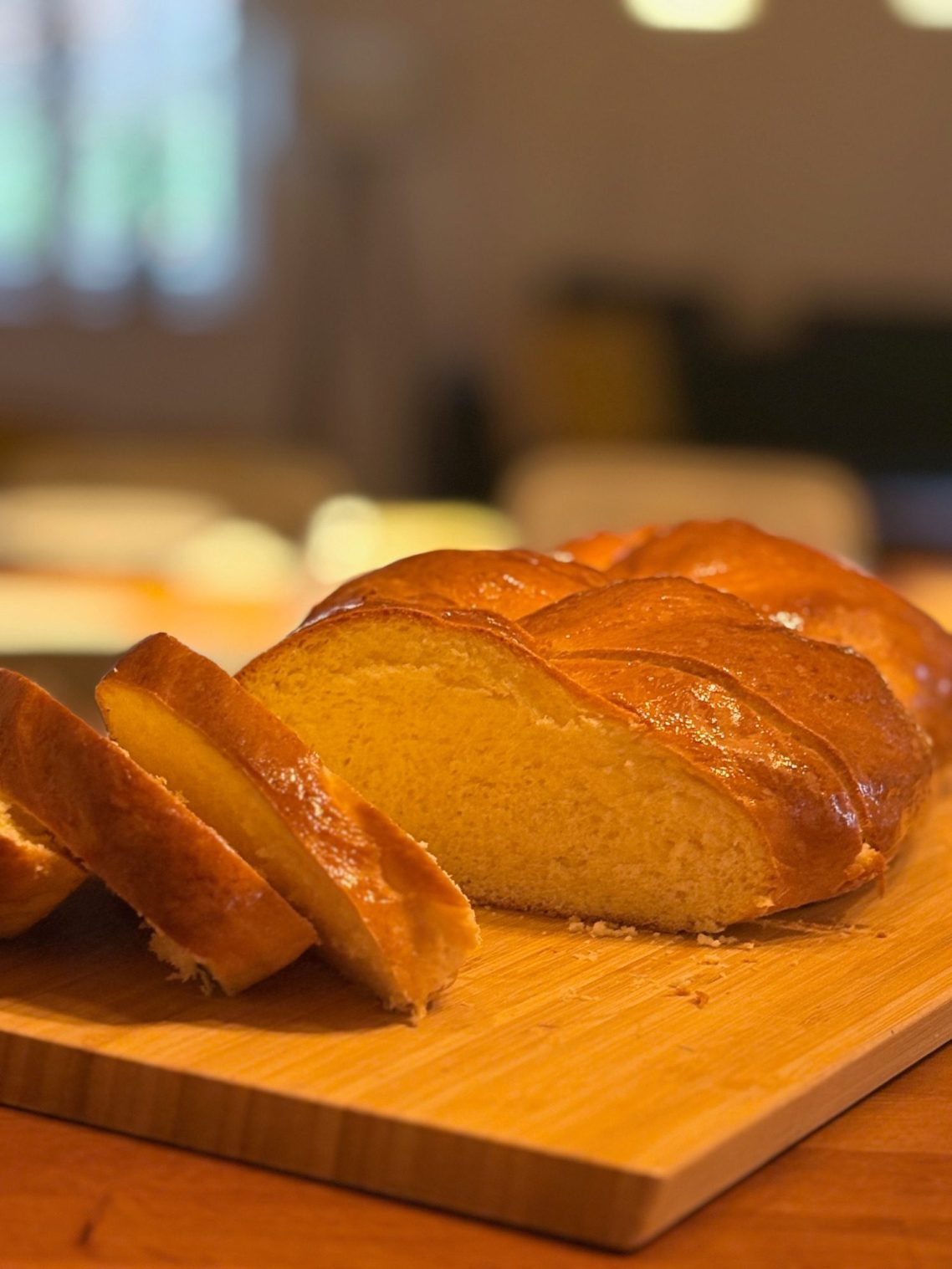 Helles, frisch gebackenes Brot mit einer goldenen Kruste auf einem Holzbrett.