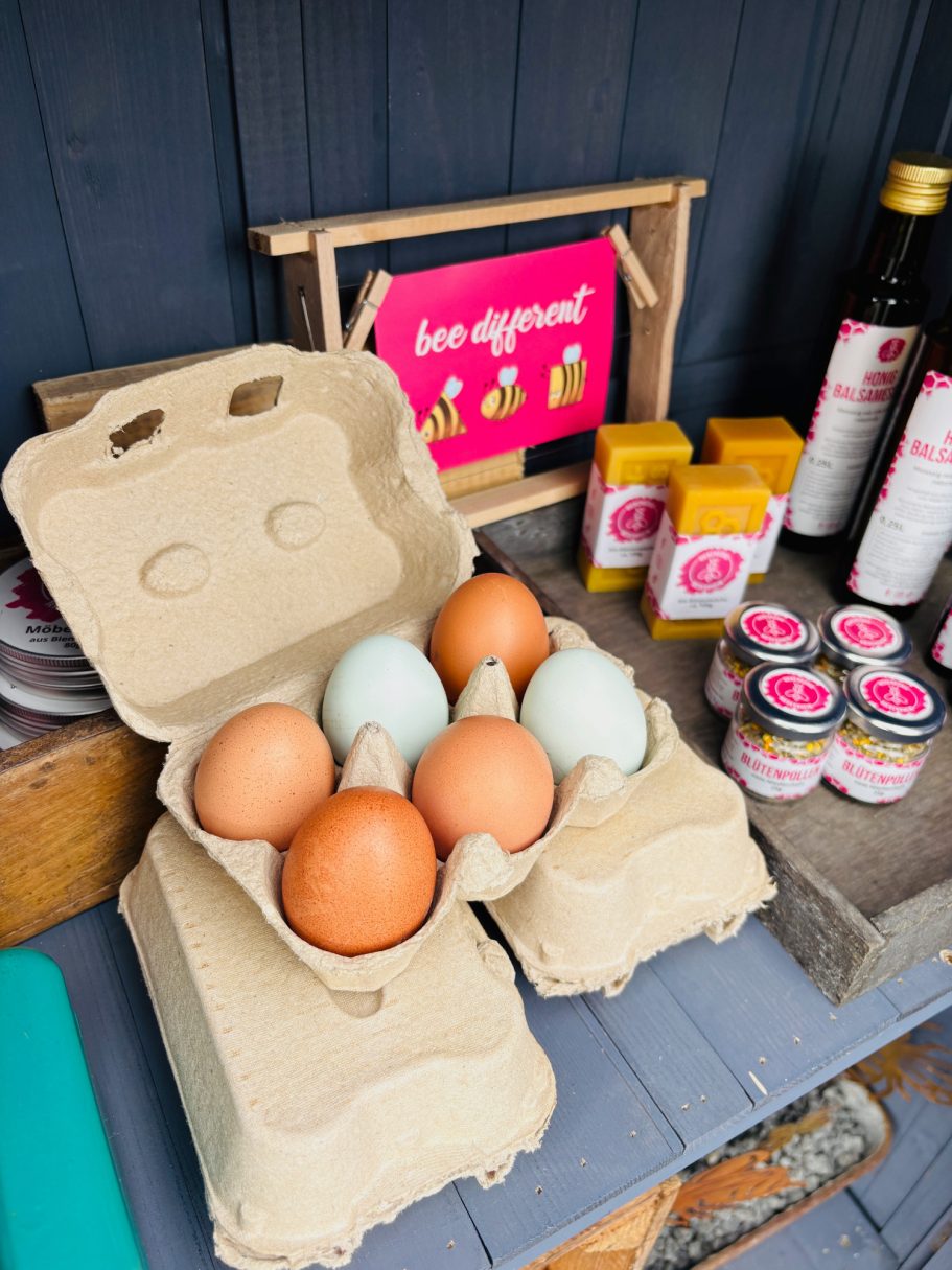 Eier in einem Eierkarton, daneben verschiedene Flaschen und Dosen.