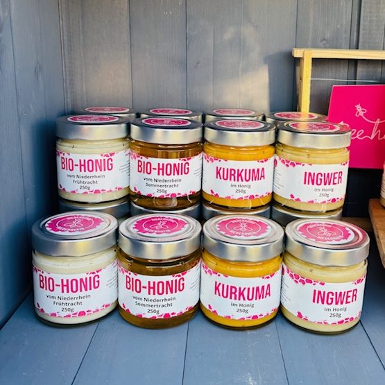 Eine Reihe von Gläsern mit farbigen Inhalten und Etiketten in einer Präsentation.