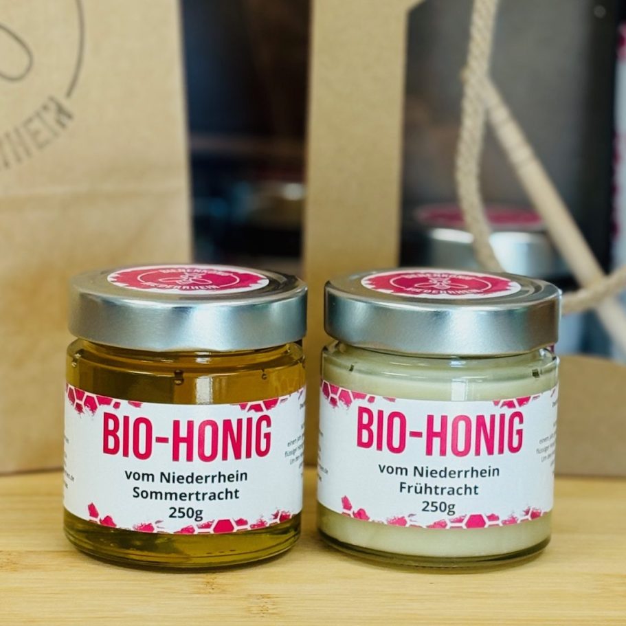 Honigweinin einem Glas neben einer Flasche und Essig, unter blauem Himmel.